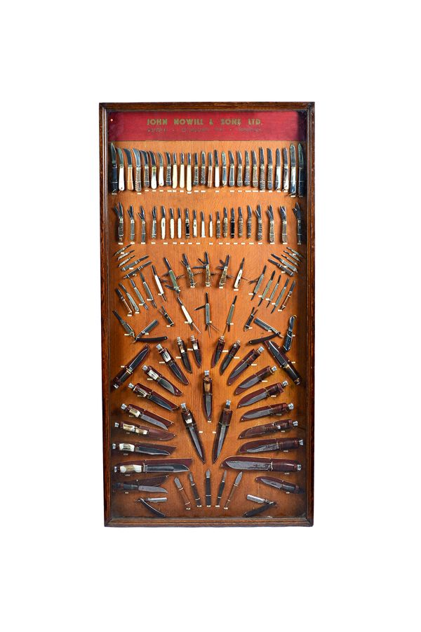A large retailer's advertising display case, 'John Nowill & Sons Ltd', 20th century, containing hunting knives, pocket knives and pen knives, backed t