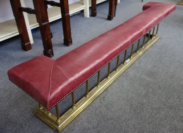 A Victorian style gilt metal and red leather upholstered club fender, with pillar supports and stepped kerb, 192cm wide.