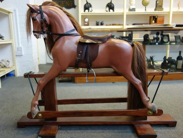 A Haddon composite rocking horse, after a model by F.H. Ayres, fibreglass painted body with leather saddle and tack, on a wood and wrought iron swing