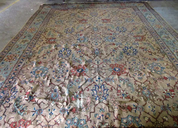 A Tabriz carpet, Persian, the brown field with an allover palmette and trellis design, with a complementary pale indigo palmette border, 393cm x 302cm