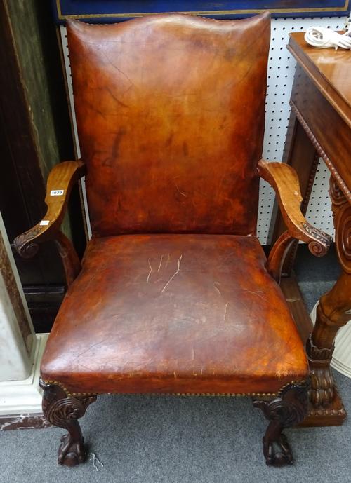 A pair of George III style open armchairs with studded rouge leather upholstery on scroll carved mahogany supports and ball and claw feet, 70cm wide x