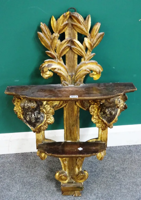 An 18th century and later North European giltwood two tier wall shelf, with winged cherub mounts amongst acanthus sprays, 55cm wide x 87cm high.