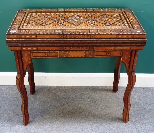 A late 19th century Middle Eastern mother-of-pearl and specimen wood parquetry inlaid rectangular fold over card table, on shaped supports united by p