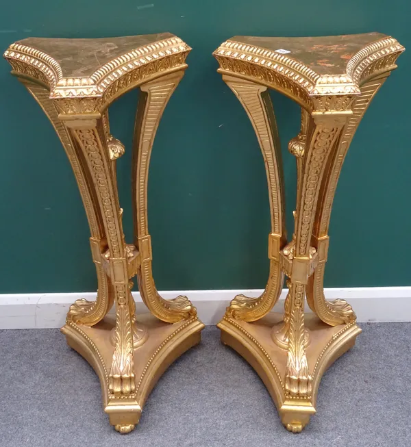 A pair of George III style gilt jardiniere stands on three swept supports and paw feet on triform platform, 36cm wide x 106cm high. (2)