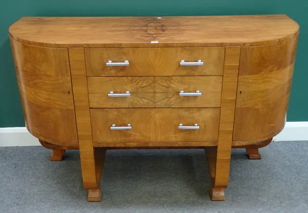 After Harry & Lou Epstein; a 1930s-1950s figured walnut sideboard with three central drawers flanked by cupboards, on open 'U' shaped supports, 152cm