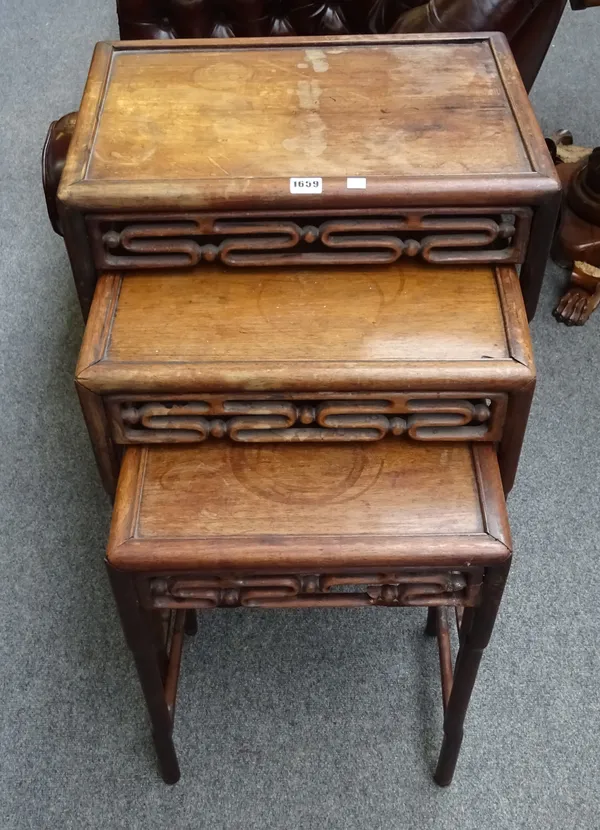 A nest of three late 19th century Chinese hardwood tables, each with pierced frieze on turned supports, the largest 51cm wide x 72cm high x 32cm deep.