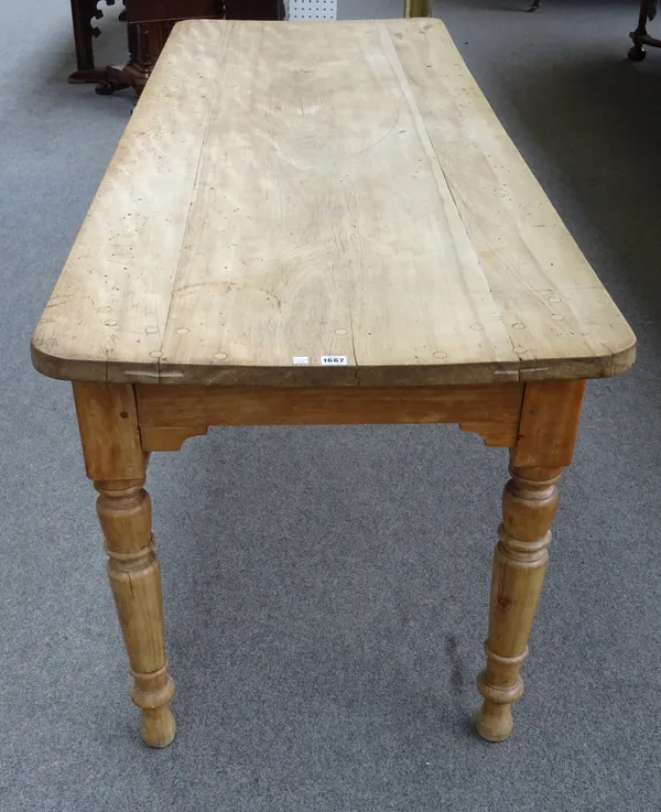 A 19th century beech kitchen table, the plank top on turned supports, 77cm wide x 207cm long x 75cm high.