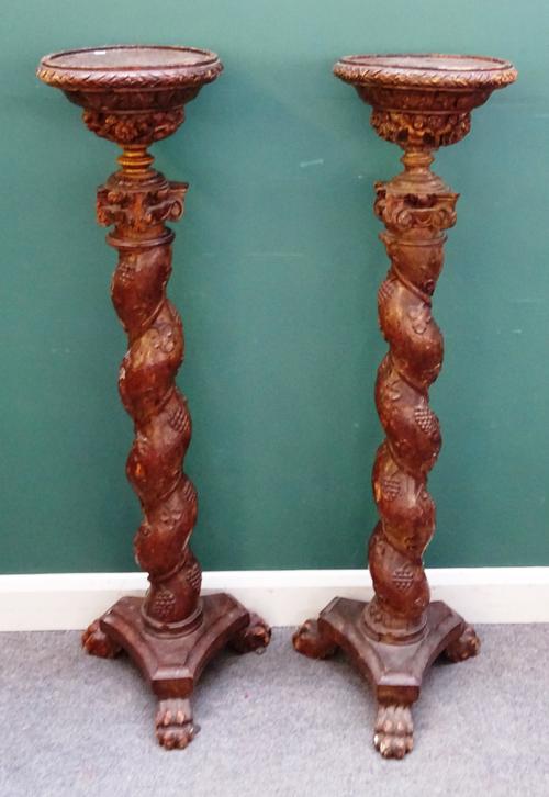 A pair of 18th century and later Italian walnut jardiniere stands with barley-twist and fruiting vine carved column on paw feet, 133cm high. (2)