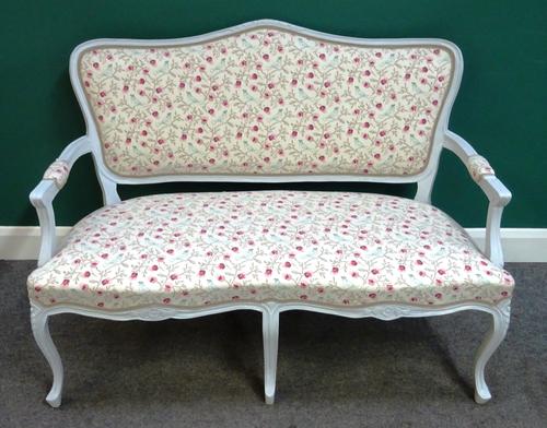 A 20th century open arm sofa, with grey painted show frame and double serpentine seat, on floral capped cabriole supports, upholstered in birds and fa