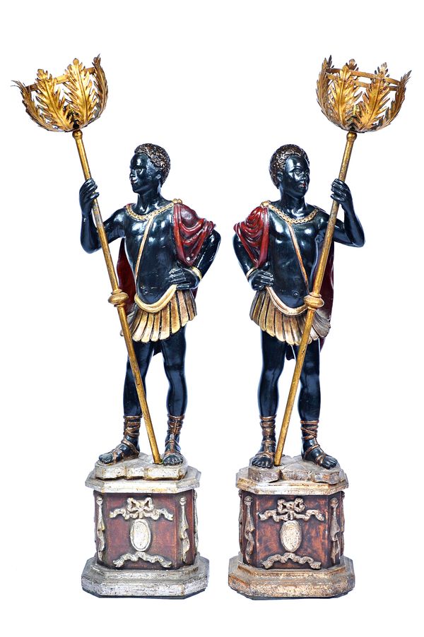 A pair of Blackamoor figural lamps, each modelled in gladiatorial pose, holding a torchère, on compressed octagonal bases, approximately 140cm high, (