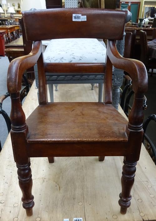 An early 19th century mahogany child's open armchair, on turned supports, 37cm wide x 66cm high.