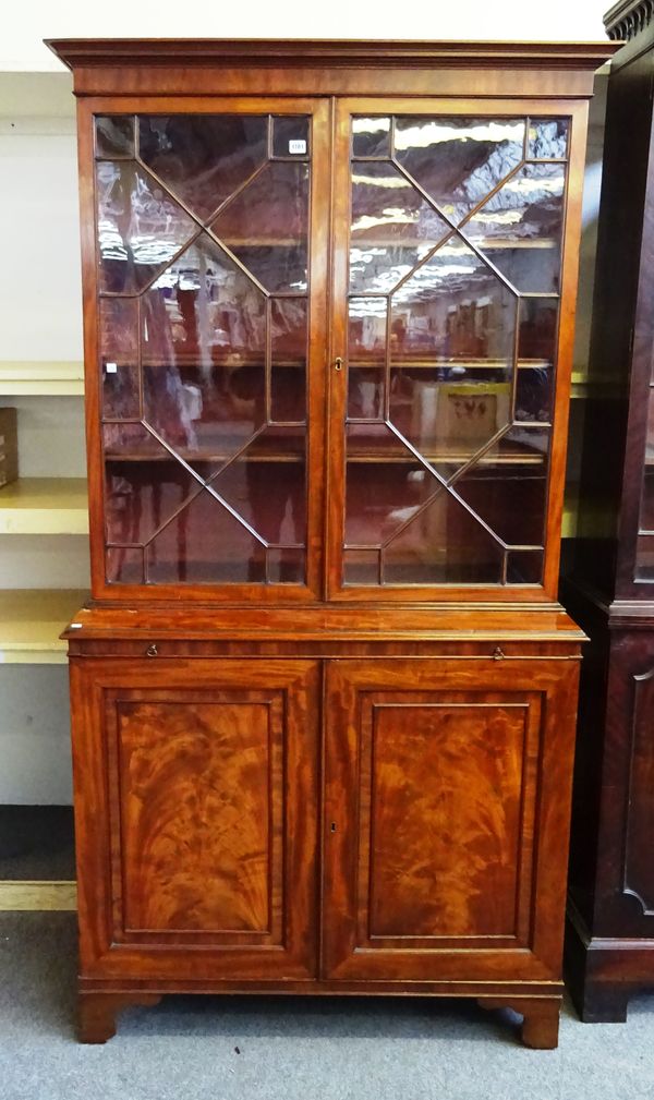 A George III mahogany bookcase cabinet, the pair of astragal glazed doors over brushing slide and pair of cupboard doors, on bracket feet, 111cm wide