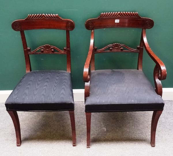 A set of fourteen Regency style mahogany dining chairs, circa 1900, with carved crest and waist rail on sabre supports, to include a pair of carvers,