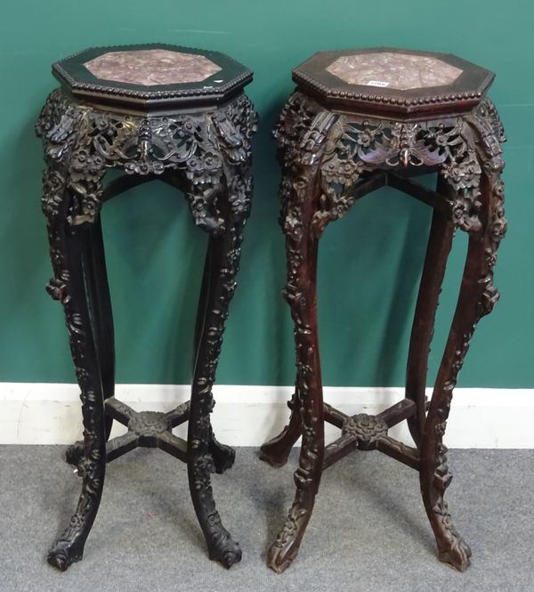 A late 19th century Chinese hardwood urn stand, the octagonal marble inset top over a pierced and carved frieze, on four slender cabriole supports, 45