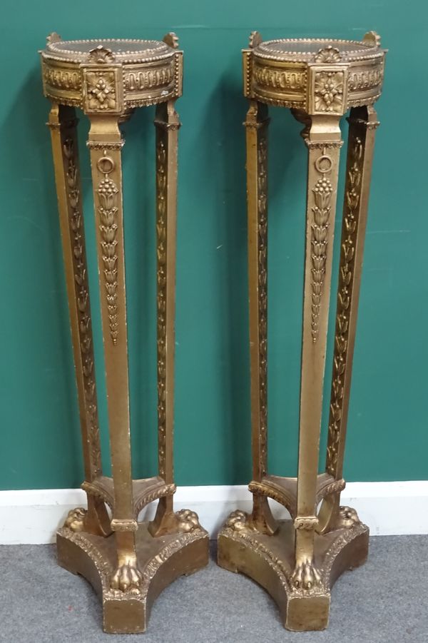 A pair of Regency style gold painted jardiniere stands, with circular top and paw feet, on trefoil platform, 35cm wide x 124cm high. (2)