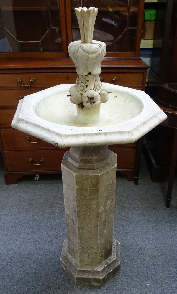 A carved marble fountain, with octagonal reservoir and floral carved spout, on octagonal stepped base, 135cm high x 65cm wide.