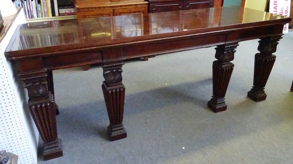 A massive William IV mahogany serving table, the rectangular top over three frieze drawers, on six lappet carved and square tapering supports, 249cm w