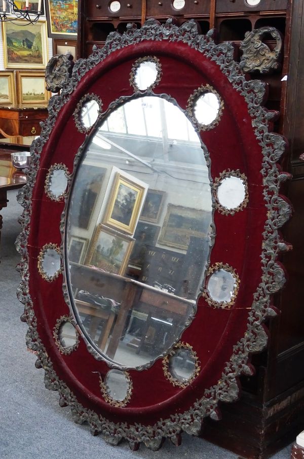 A large late 19th century French gilt metal mounted shaped oval marginal wall mirror, 125cm wide x 178cm high.