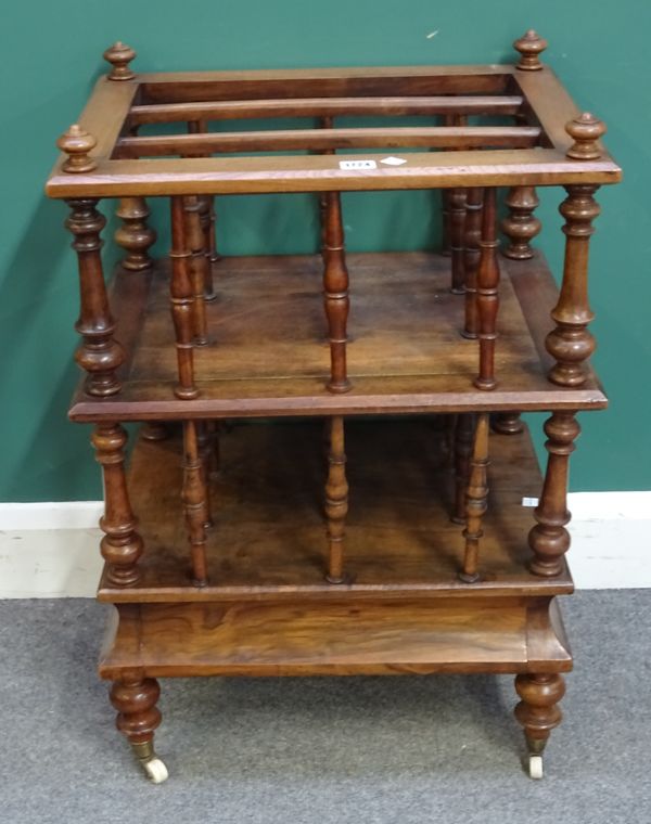 A Victorian figured walnut two tier three division Canterbury, with single drawer base on turned supports, 52cm wide x 77cm high x 40cm deep.  401