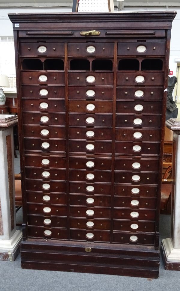 An early 20th century oak filing cabinet, the tambour front revealing a fitted interior with three rows of fourteen drawers, on a plinth base, 117cm w