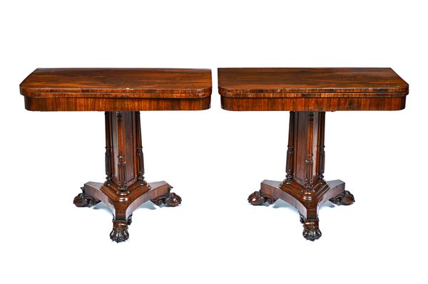 A pair of late Regency rosewood card tables, each with foldover 'D' shaped top on triangular and lappet turned columns, triform platform and three paw