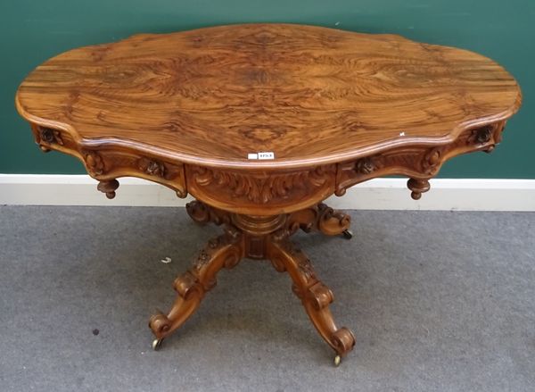 A 19th century Continental carved and figured walnut shaped centre table on turned column and four downswept supports, 129cm wide x 80cm diameter x 79