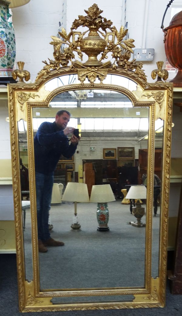 A late 19th century gilt framed wall mirror, with floral chased urn crest over segmented marginal frame, 91cm wide x 170cm high.