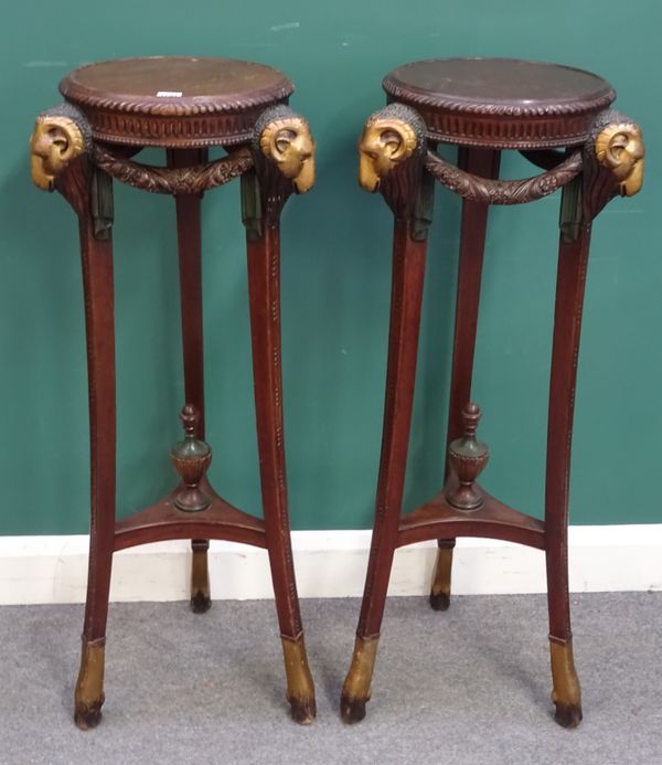 A pair of Regency style mahogany jardiniere stands, the circular tops over gilt rams heads and hairy hoof feet, 43cm wide x 107cm high. (2)