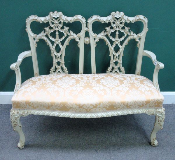 A Chippendale Revival gold and cream painted double chair back sofa, on scroll supports, 120cm wide x 98cm high.