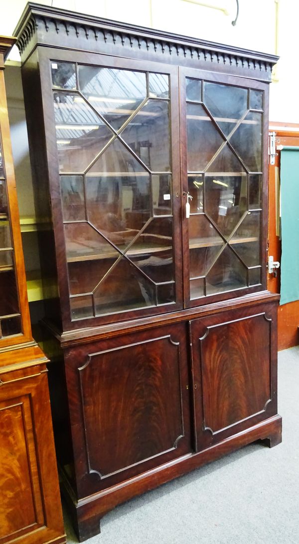 A George III mahogany bookcase cabinet, the pair of glazed doors over pair of cupboards, on bracket feet, 128cm wide x 225cm high x 41cm deep.