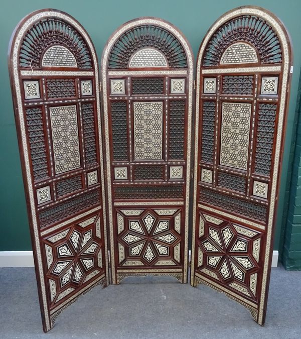 A 20th century North African mother-of-pearl inlaid arch top three fold draught screen, with bobbin turned decoration, 180cm wide x 191cm high.