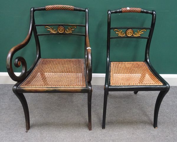 A set of eight Regency style parcel gilt and green painted dining chairs, with rope twist crest rail and bullseye waist, on sabre supports, including