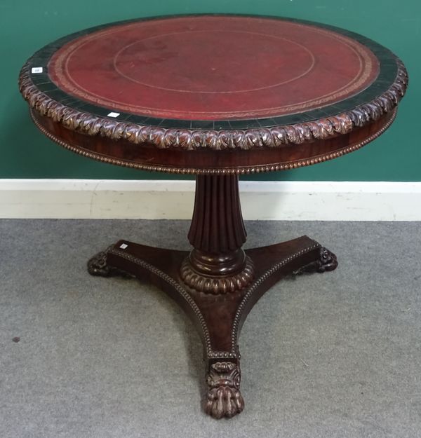 A Regency rosewood centre table, the leather inset circular top with carved frieze, on flared reeded column, trefoil platform and carved paw feet, 90c