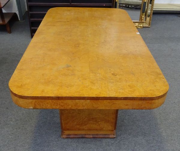 An Art Deco figured ash and walnut dining table, the rounded rectangular top on a pair of black pedestal supports, 182cm long x 92cm wide x 75cm high.