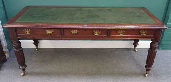 An early Victorian mahogany writing table with three frieze drawers on reeded supports, 180cm wide x 75cm high x 76cm diameter.