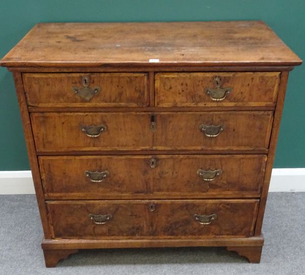 An early 18th century figured walnut and oak chest of two short and three long graduated drawers, on bracket feet, 100cm wide x 94cm high x 57cm deep.