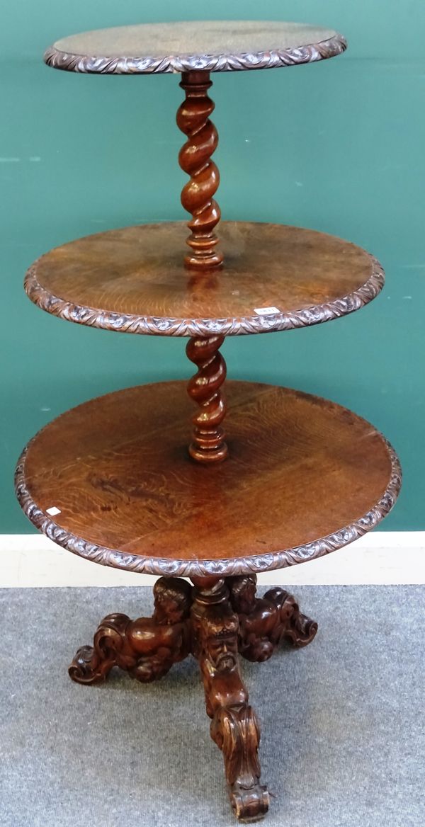 A mid-19th century carved oak graduated circular three tier dumb waiter, on figural carved tripod base, 70cm diameter x 130cm high.