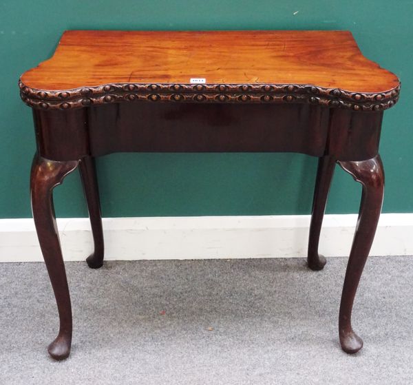 A George II mahogany card table, with shaped fold out top, on cabriole supports and pad feet, 81cm wide x 74cm high x 39cm deep.