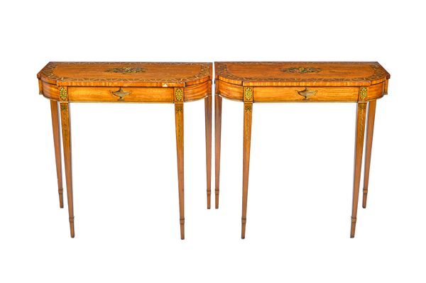 A pair of George III style polychrome painted satinwood console tables, each with breakfront 'D' shaped tops on tapering square supports, 92cm wide x