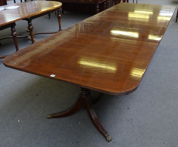 A made-up Regency style mahogany four pedestal extending dining table, each pedestal with turned and baluster reeded columns and three downswept suppo