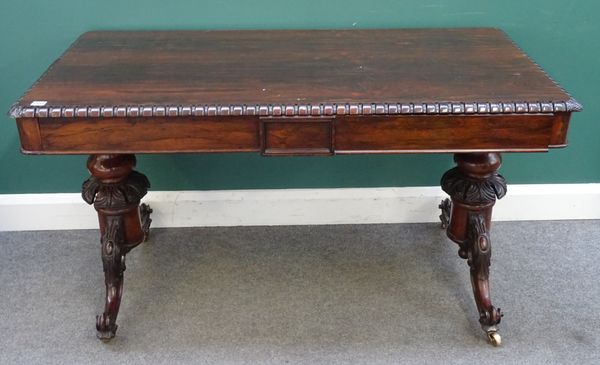 A Victorian rosewood centre writing table, the rounded rectangular top over pair of frieze drawers, on baluster turned columns and four carved downswe