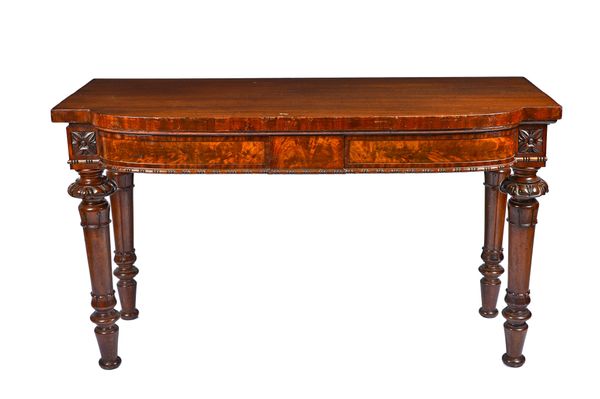 A pair of William IV mahogany serving tables, each with break front 'D' shaped top and flush fit frieze drawer, on lappet carved and turned supports,