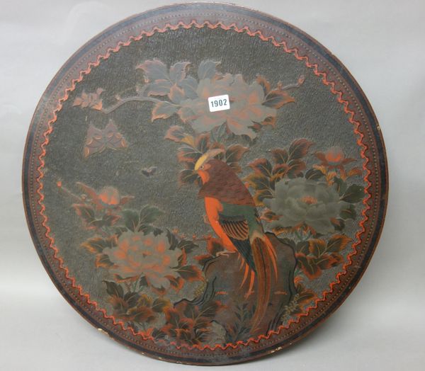 A Japanese lacquered wood roundel, Meiji period, carved in low relief with a bird perched on a rock amongst flowering shrubs, 60cm. diameter.  3095 SN