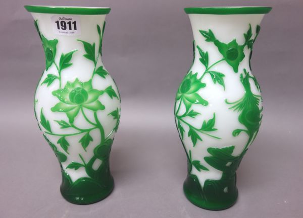 A pair of Chinese overlay glass vases, 20th century, of slender baluster form, each overlaid in green with a bird amongst flowers and rocks, 26.5cm. h