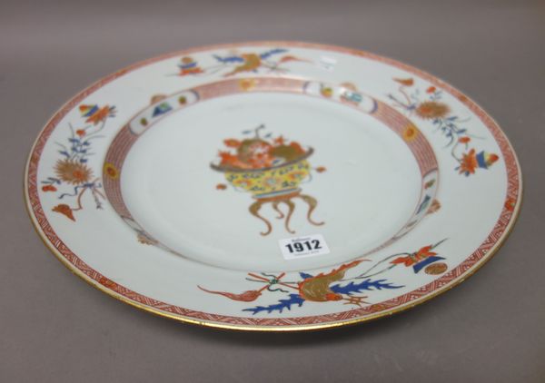 A Chinese export porcelain dish, 18th century, painted in the centre with a yellow-ground vase filled with fruit and flowers, 35.5cm. diameter.