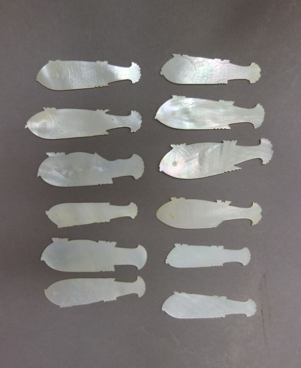 A group of Chinese mother-of-pearl gaming counters, 19th century, each of fish form with engraved details, the reverse engraved with a panel of two lo