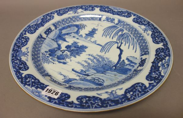 A Chinese blue and white large plate, Qing dynasty, 18th century, painted with a river landscape with a boat and buildings, beneath a floral border, 3