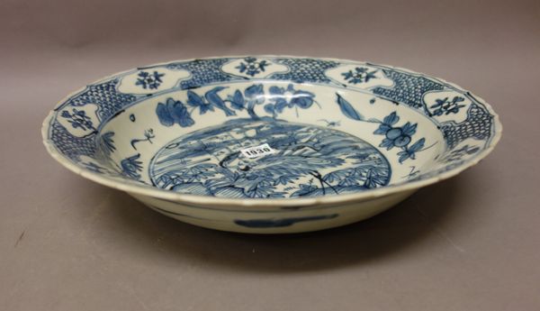 A large Chinese Swatow ware blue and white deep dish, late Ming dynasty, late 16th/17th century, painted in the centre with a stork standing on rocks