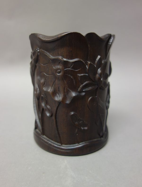 A Chinese hardwood brush pot, 20th century, of cylindrical form, carved with lotus flowers, 12.5cm. high.