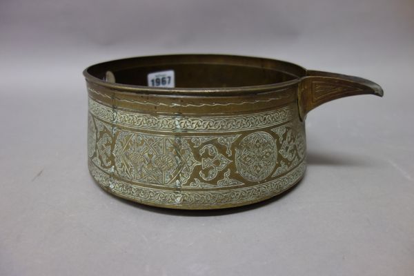 A Mamluk engraved brass pouring vessel, probably 15th century, with tapering sides and everted spout, engraved with panels of script and geometric des